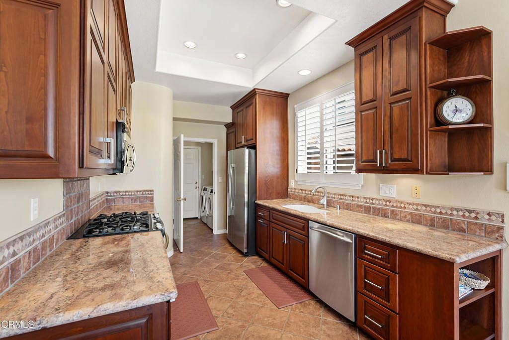 Chef's kitchen with granite countertops and warm wood cabinetry